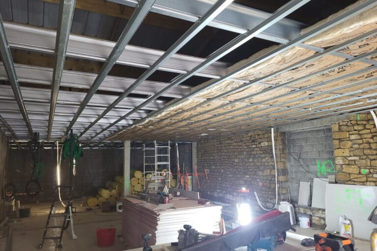 Intérieur d'un chantier de rénovation avec structure métallique, briques apparentes, matériaux de construction et.